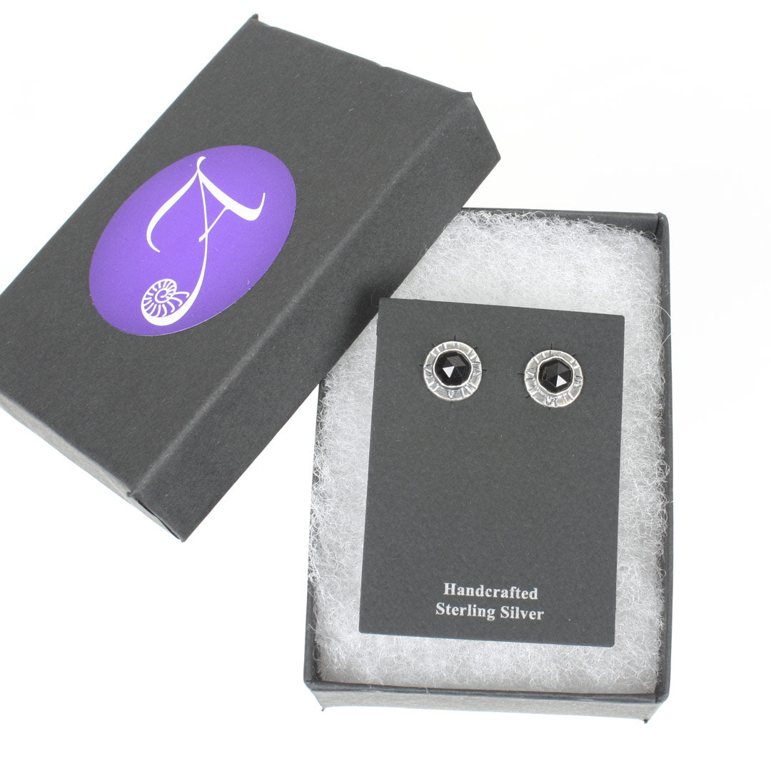 Sterling silver earrings with faceted rose-cut black spinel. Shown displayed in a black gift box with the Arcana Metalwork logo.