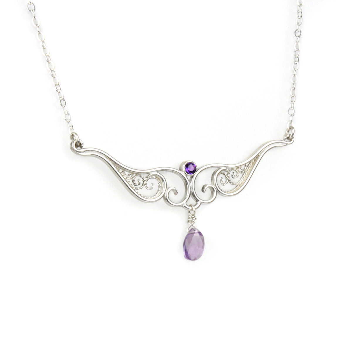 A graceful silver necklace with delicate filigree wirework, accented with purple amethyst, on a white background.