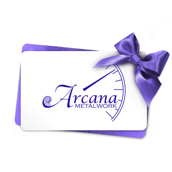 An image of a white gift card with a purple Arcana Metalwork logo, with a purple satin bow and sparkly purple sleeve.